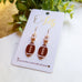 Gold Football Dangle Earrings with Cubic Zirconia Accent “Blitz”